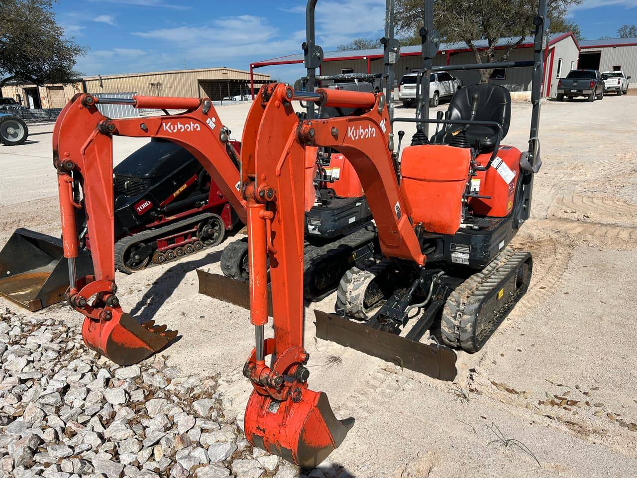 Orange Kubota mini excavators with buckets and dozer blades on the 4-T Rental & Sales yard